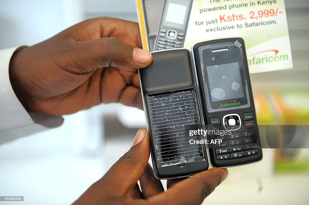 A Kenyan client holds a solar panel phon