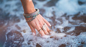 Young woman with boho style jewelry at the beach