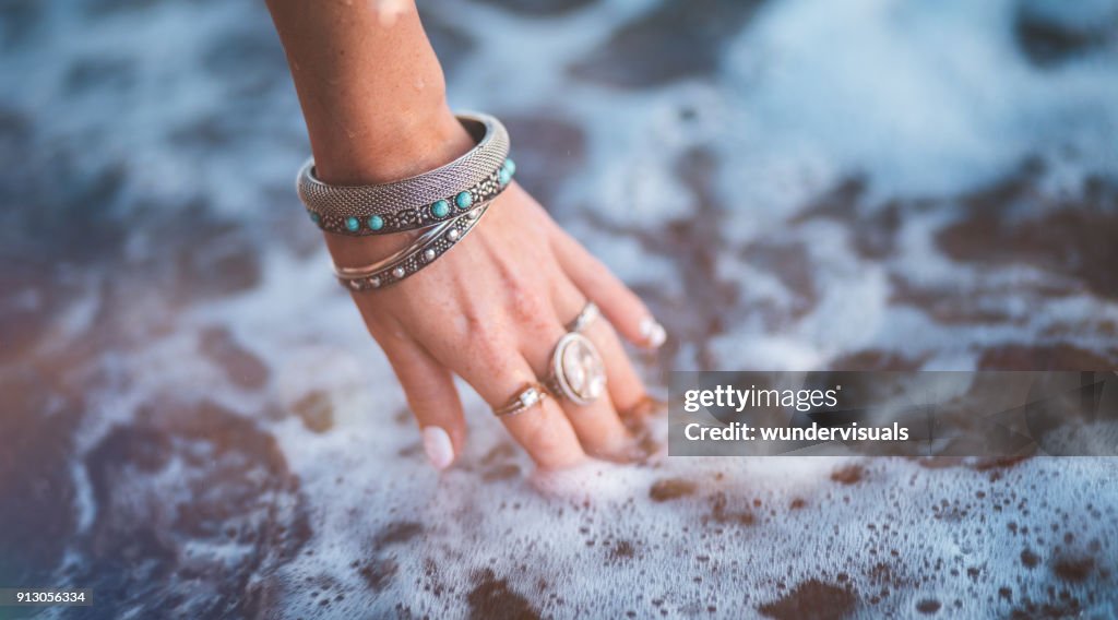 Young woman with boho style jewelry at the beach