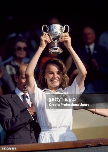 Martina Hingis of Switzerland lifts the trophy after defeating Jeon Mi-ra of South Korea in the Junior Girls' Singles Final of the Wimbledon Lawn...