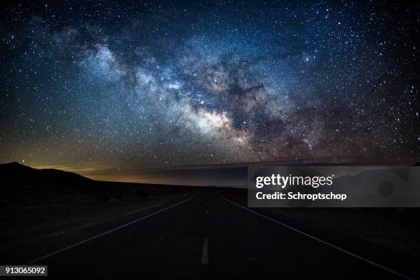 milky way over country road - death valley, usa - parque nacional do vale da morte imagens e fotografias de stock
