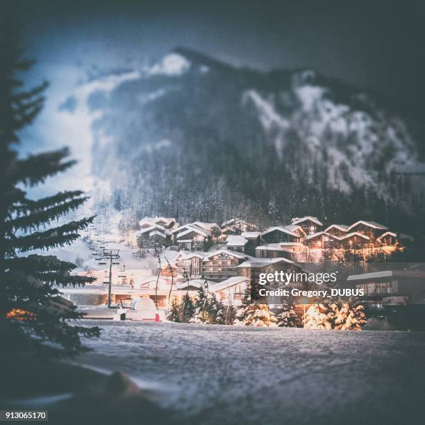 val d'isere french ski resort illuminated village by snowy night in european alps in winter - deep snow skiing stock pictures, royalty-free photos & images