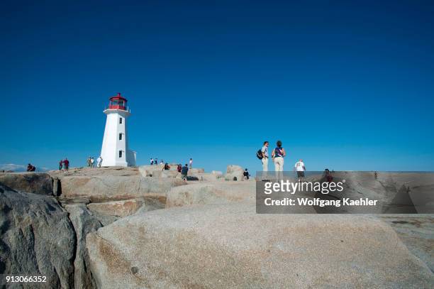 People visiting lighthouse at Peggy's Cove near Halifax, Nova Scotia, Canada.