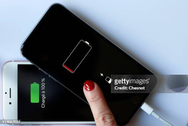 In this photo illustration, Apple mobile phones iPhone 6 on screens of which we can see the battery charge indicator is displayed on February 01,...