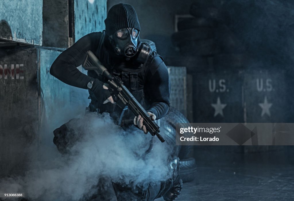Gasmask bär ensam soldat i rökiga inomhus urban miljö