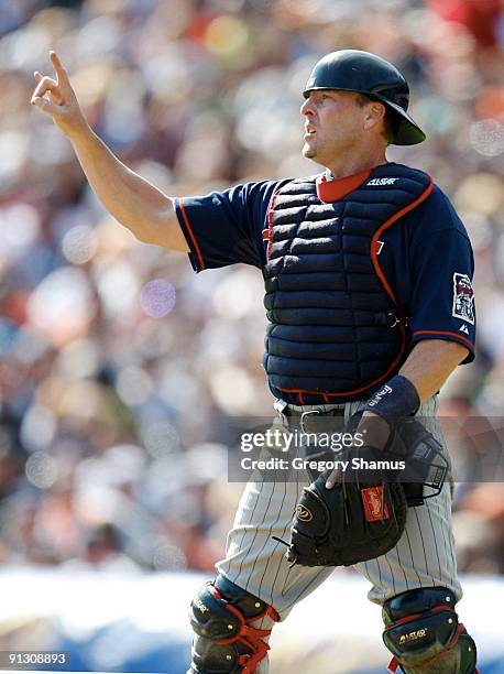 Catcher Mike Redmond of the Minnesota Twins puts holds up his fingers signaling 'two-outs' against the Detroit Tigers during the game on October 1,...