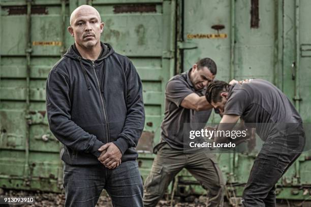 krav maga fighting instructor posing during training session in grimy outdoor setting - self defense stock pictures, royalty-free photos & images