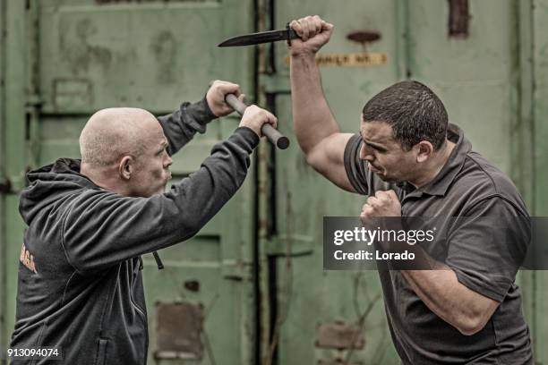 krav maga fighting duo sparring during training session in grimy outdoor setting - soldier shouting stock pictures, royalty-free photos & images