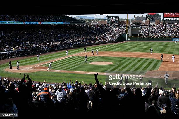 Rockies fans cheer as Aaron Cook of the Colorado Rockies is walked with the bases loaded by starting pitcher Manny Parra of the Milwaukee Brewers to...