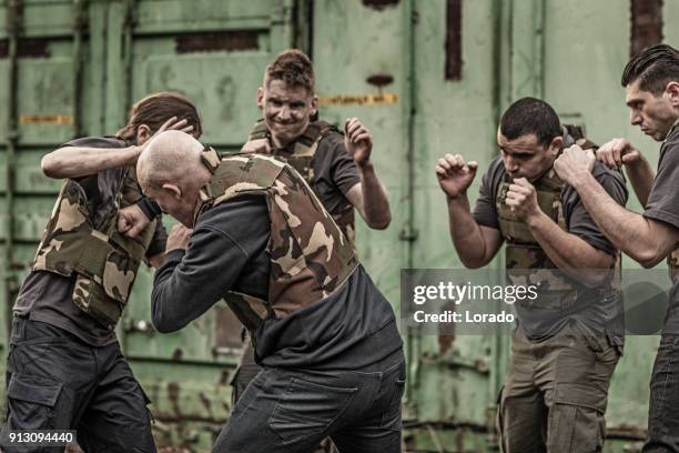 krav maga fighting group sparring during training session in grimy outdoor setting - committee of public security and fight stock pictures, royalty-free photos & images