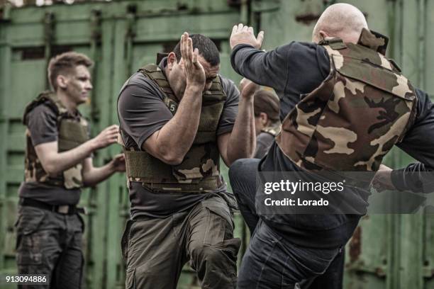 krav maga fighting group sparring during training session in grimy outdoor setting - committee of public security and fight stock pictures, royalty-free photos & images