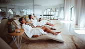 Young women in white robes relaxing at beauty spa centre