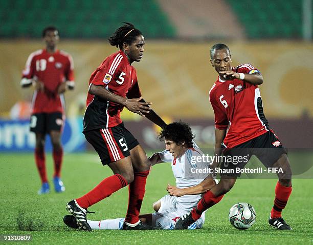 Hernan Perez of Paraquay is challenged by Akeem Adams and Leston Paul of Trinidad and Tobago during the FIFA U20 World Cup Group A match between...