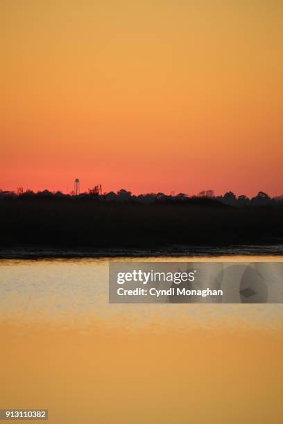 glowing sunset off of assateague island - küstenschutzgebiet assateague island stock-fotos und bilder