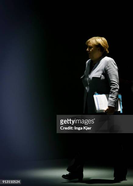 German Chancellor Angela Merkel walks to a press conference after a meeting with regional state leaders as part of regular consultations on February...