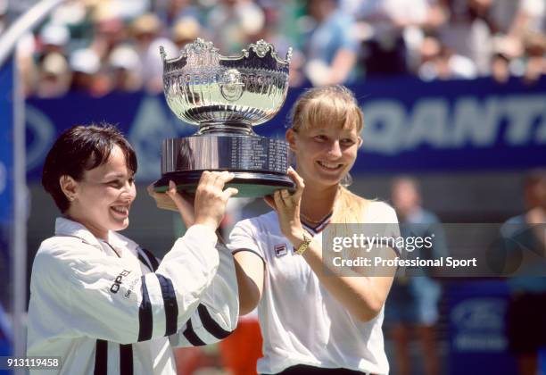 Doubles partners Martina Hingis of Switzerland and Mirjana Lucic of Croatia pose with the trophy after defeating Lindsay Davenport of the USA and...