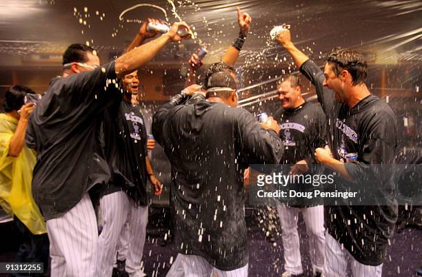 The Colorado Rockies shower each other with beer and champagne as celebrate in the clubhouse after they defeated the Milwaukee Brewers 9-2 and...