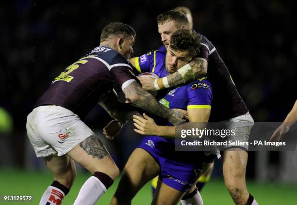 Warrington's Joe Philbin is tackled by Leeds Rhino's Brett Delaney and Adam Cuthbertson during the Betfred Super League match at the Halliwell Jones...