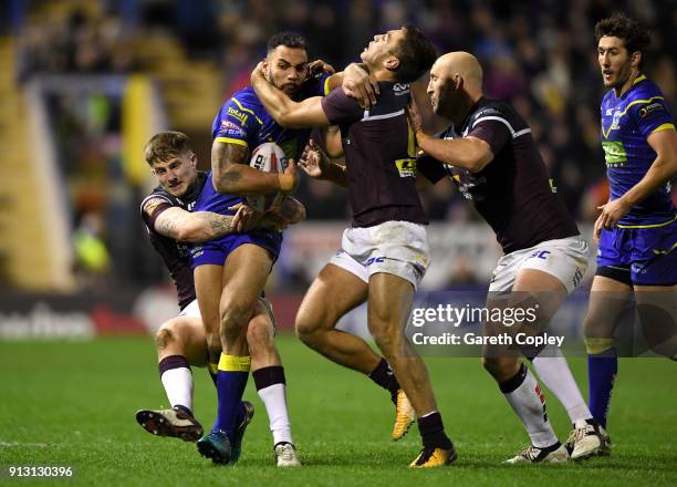 Ryan Atkins of Warrington is tackled by Liam Sutcliffe, Matt Parcell and Carl Ablett of Leeds during the Betfred Super League match between...