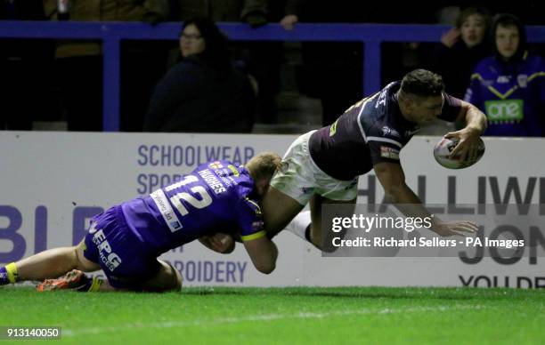 Leeds Rhino's Ryan Hall dives over to score as Warrington's Jack Hughes tackles during the Betfred Super League match at the Halliwell Jones Stadium,...