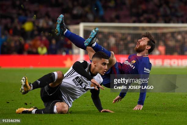Valencia's Brazilian forward Andreas Pereira clashes with Barcelona's Argentinian forward Lionel Messi during the Spanish 'Copa del Rey' first leg...