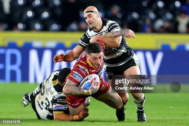 Oliver Roberts of Huddersfield Giants is tackled by Hull FC's Mickey Paea and Danny Houghton during the BetFred Super League match between Hull FC...