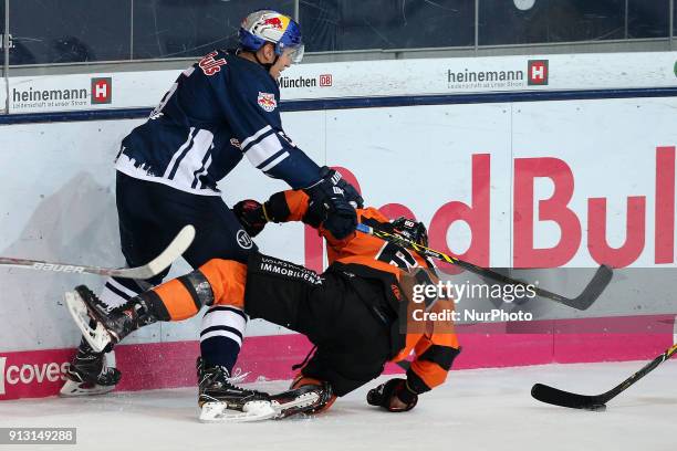 Keith Aulie of Red Bull Munich vies Philip Riefers of Grizzlys Wolfsburg during the 49th game day of the German Ice Hockey League between Red Bull...