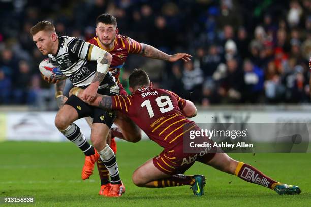 Hull FC's Marc Sneyd is tackled by Daniel Smith and Oliver Roberts of Huddersfield Giants during the BetFred Super League match between Hull FC and...