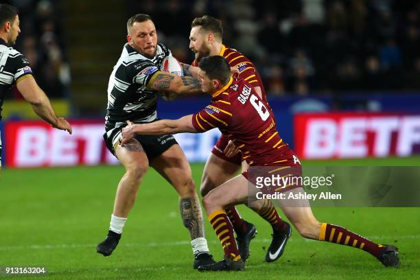 Josh Griffin of Hull FC breaks through tackles of Huddersfield Giants Lee Gaskell and Jordan Rankin during the BetFred Super League match between...