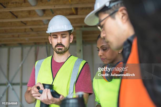 travailleurs de la construction sur pause café en regardant mobile - australian culture stock photos et images de collection