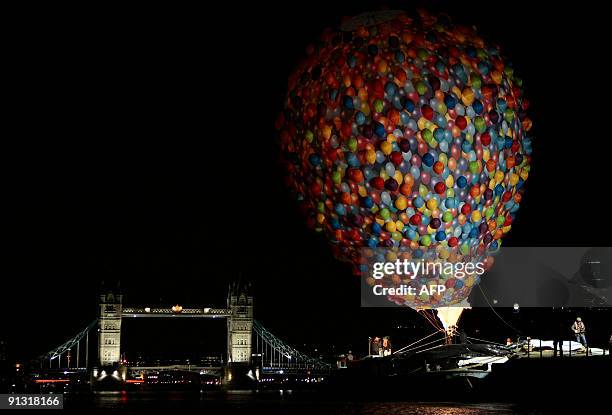 Hot air balloon made up of lots of smaller balloons and tied to a barge is inflated before being flown under Tower Bridge in central London, on...