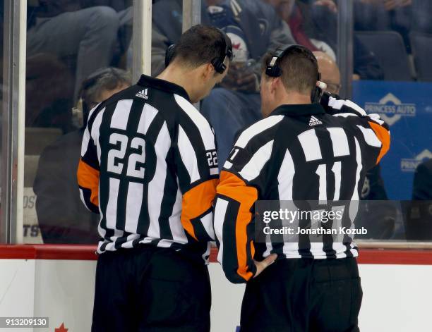 Referees Ghislain Hebert and Kelly Sutherland review a Vegas Golden Knights goal on a Coaches Challenge for Goaltender Interference during second...