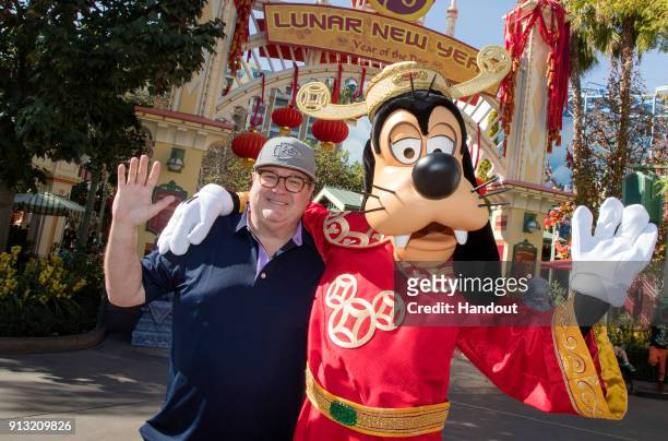In this handout photo provided by Disneyland Resorts, actor Eric Stonestreet poses with Goofy, dressed in "god of Good Fortune" garments, during the...