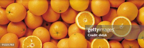 sliced and whole oranges in a group - sinaasappel stockfoto's en -beelden