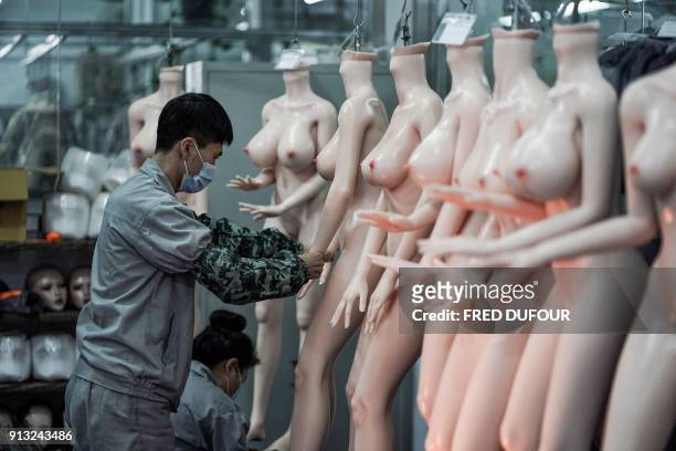 Graphic content / TOPSHOT - This photo taken on February 1, 2018 shows a worker preparing silicone dolls at a factory of EXDOLL, a firm based in the...
