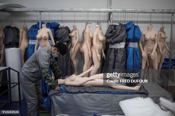 Graphic content / TOPSHOT - This photo taken on February 1, 2018 shows a worker preparing a silicone doll at a factory of EXDOLL, a firm based in the...