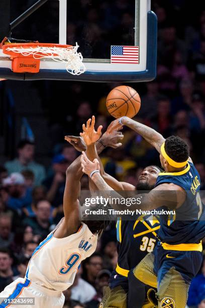 Kenneth Faried and Torrey Craig of the Denver Nuggets block Jerami Grant of the Oklahoma City Thunder at Pepsi Center on February 1, 2018 in Denver,...