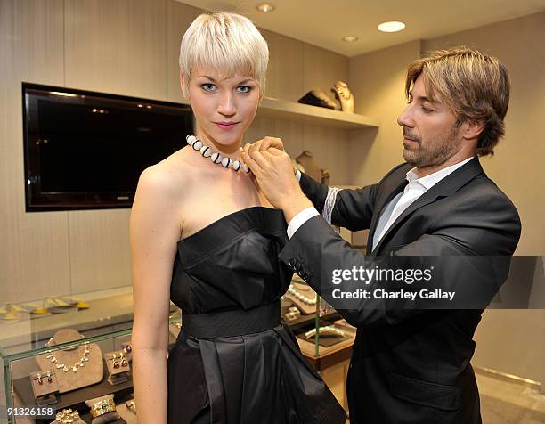 Jewelry designer Roberto Faraone Mennella places a necklace on a model at a personal appearance by Faraone Mennella at Saks Fifth Avenue on October...