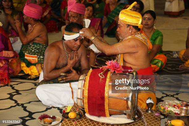 Tamil Hindu priest blesses a drummer after blessing his thavil drum during the Theertham Thiruvizha Festival at a Tamil Hindu temple in Ontario,...
