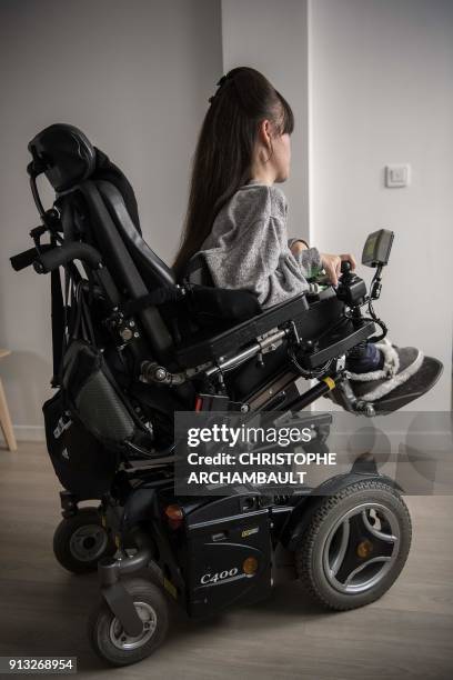 Disabled woman is pictured in her wheelchair at her flat in Paris on January 18, 2018.