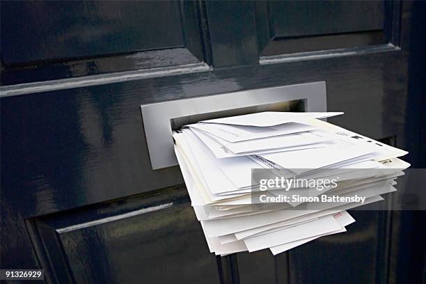 front door letterbox stuffed with mail - ranura de buzón fotografías e imágenes de stock