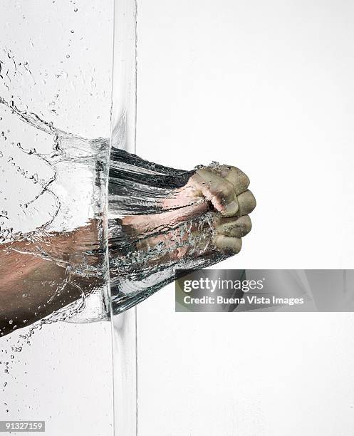 fist braking a water wall - breaking through wall stockfoto's en -beelden