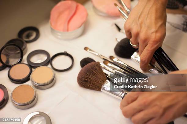 make-up artist sorting through brushes on the table - make up table stock pictures, royalty-free photos & images