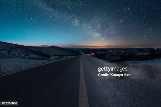 starry night with empty windy road - mountain range night stock pictures, royalty-free photos & images