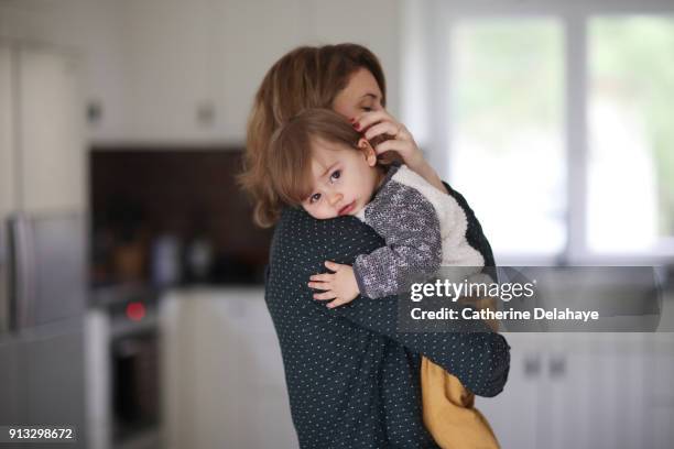 a mum hugging her 1 year old baby boy in the kitchen - 2 year old child fotografías e imágenes de stock