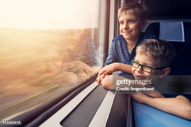 weinig brotheres genieten van reizen per trein - trein stockfoto's en -beelden