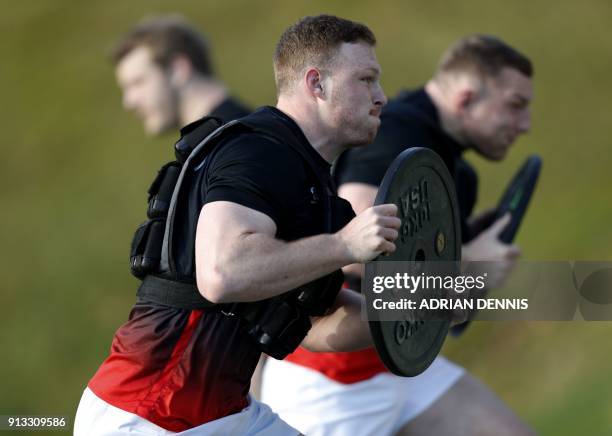 England's number 8 Sam Simmonds and England's flanker Sam Underhill run with weights during a team training session at Pennyhill Park in Bagshot,...