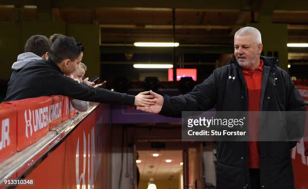 Wales head coach Warren Gatland high fives a young fan before the captain's run ahead of their opening Six Nations match against Scotland at...
