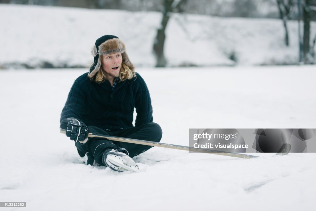 Hockey Player Fallen Sitting on Ice