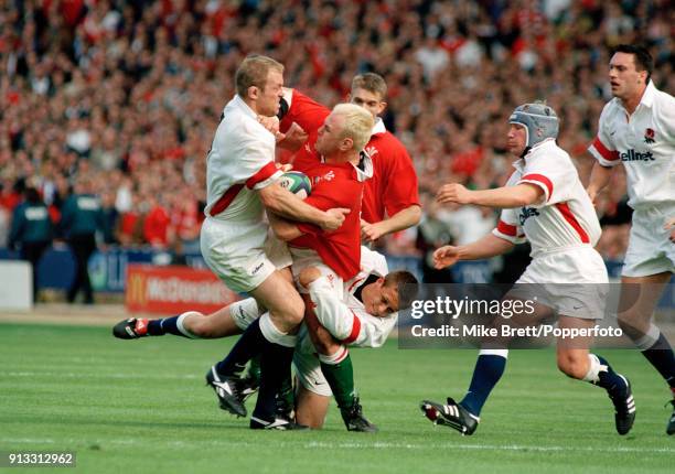 Scott Quinnell of Wales is tackled by Tim Rodber and Jonny Wilkinson as Neil Back moves in during the Five Nations Championship rugby union match...